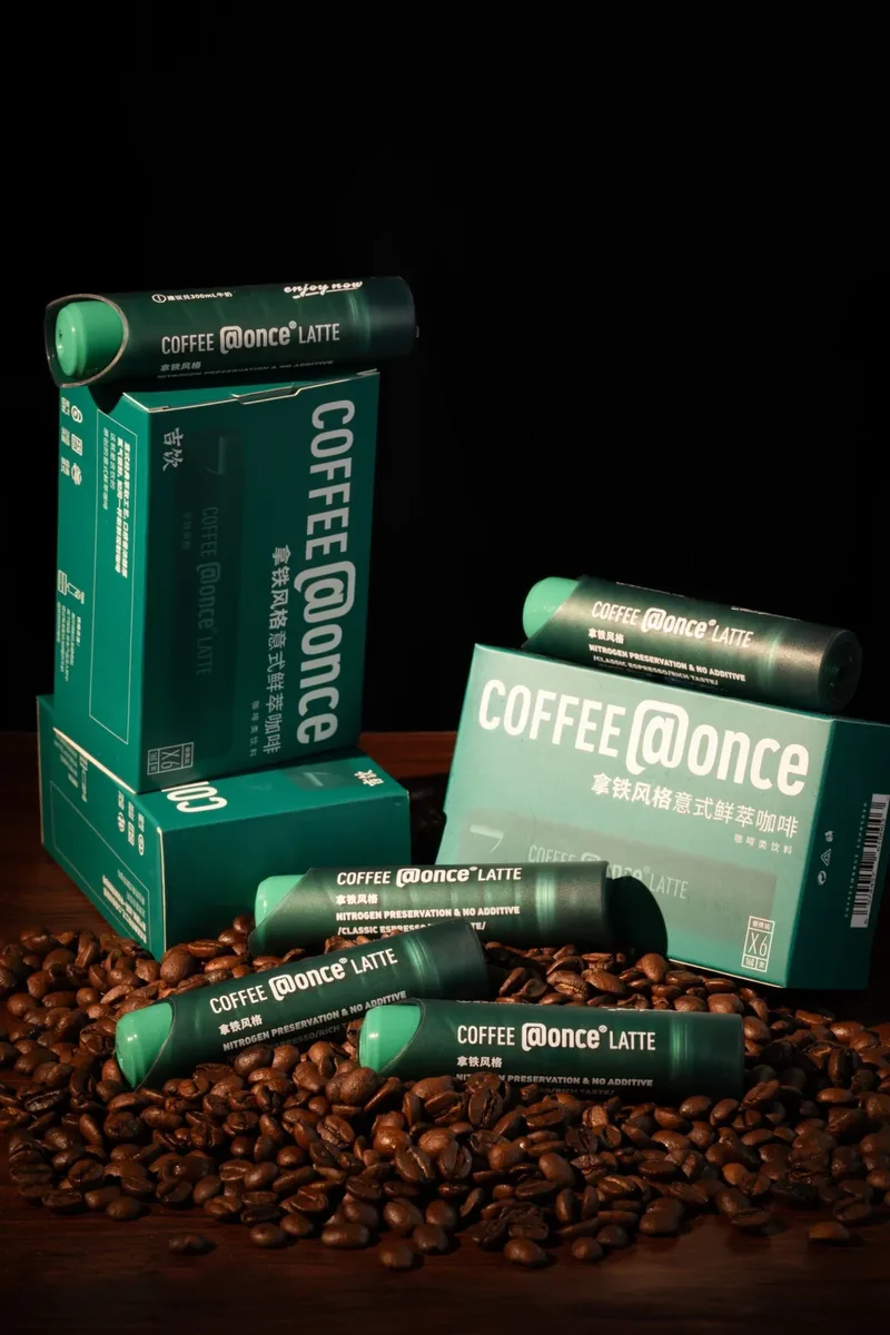Cafe at Once Latte tubes and 6-pack boxes on roasted coffee beans